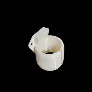 Può includere: Supporto da parete in plastica bianca per un oggetto rotondo, come una bottiglia d'acqua o una lattina. Il supporto ha uno schienale piatto con un foro per l'appeso e un frontale cilindrico con un'apertura divisa.