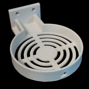 May include: White plastic wall mount with a circular, open-grid design. The mount is designed to hold a round object, such as a speaker or a light.