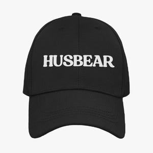 May include: A black baseball cap with the word "HUSBEAR" embroidered in white on the front.