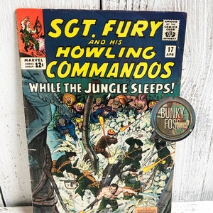 May include: A vintage comic book cover featuring Sgt. Fury and his Howling Commandos. The cover art depicts the commandos in a jungle setting, with the text "While the Jungle Sleeps!" printed in bold letters.