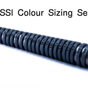 Puede incluir: Un juego de calibradores de tamaño de anillo de plástico negro con números del 4,5 al 14,5. Los calibradores están dispuestos en una fila sobre una superficie blanca. El texto "ISSI Colour Sizing Set" es visible sobre los calibradores.