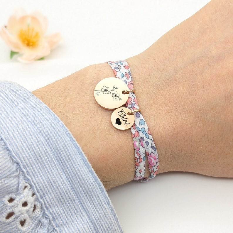 Bracelet personnalisé en cordon liberty avec une médaille de 15 mm gravée d'une ou plusieurs fleurs de naissance et médailles de 10mm gravées d'un texte.