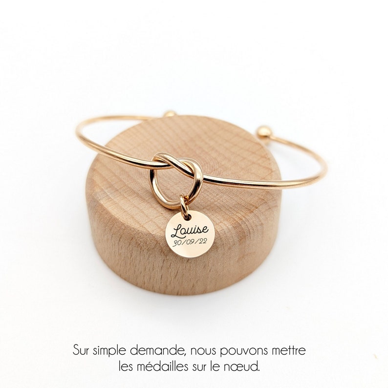 Bracelet personnalisé jonc avec nœud central. Bracelet proposé en trois coloris: Nombre de médailles au choix et gravure libre.