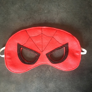 Peut inclure: Masque pour les yeux en feutre rouge avec un motif de toile d'araignée en feutre noir et des trous pour les yeux.