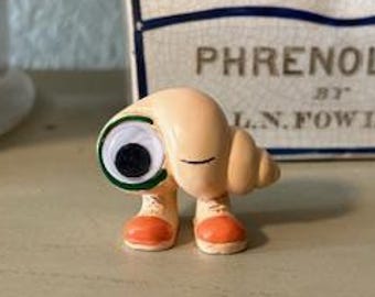 Marcel the Shell with Shoes on. TOY • 1.875" x 1.75"