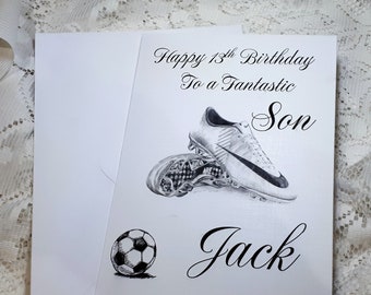 May include: A white card with black text that reads "Happy 13th Birthday To a Fantastic Son Jack". A black and white drawing of a soccer cleat and a soccer ball are on the card.