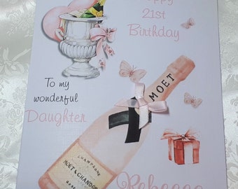 Może przedstawiać: Różowa i biała kartka urodzinowa z butelką szampana, kieliszkiem szampana i pudełkiem prezentowym. Na kartce napisano "Happy 21st Birthday" i "To my wonderful Daughter" oraz podpisano "Rebecca".