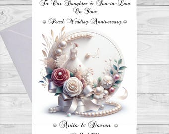 Può includere: Un biglietto bianco con un augurio di buon anniversario di matrimonio di perle. Il biglietto presenta una collana di perle bianche, un abito bianco e fiori rosa e bianchi. Il testo sul biglietto recita "To Our Daughter & Son-in-Law On Your Pearl Wedding Anniversary" e "Anita & Darren 16th March 2024".