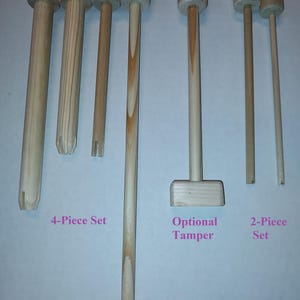 May include: Set of wooden dowels for crafting, including a 4-piece set, a 2-piece set, and an optional tamper. The dowels are all natural wood color.