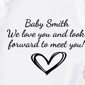 A personalised baby vest in white available in short or long sleeves. Customised text can be applied making it tailored to meet your needs for any occasion. Unique heart icon applied which the design can be applied in any colour of your choice.