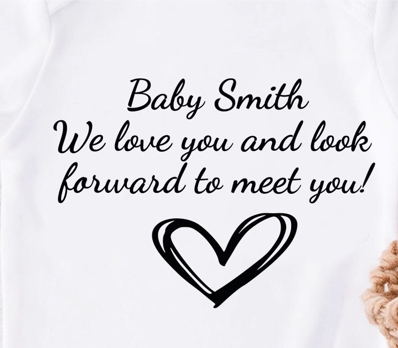 A personalised baby vest in white available in short or long sleeves. Customised text can be applied making it tailored to meet your needs for any occasion. Unique heart icon applied which the design can be applied in any colour of your choice.