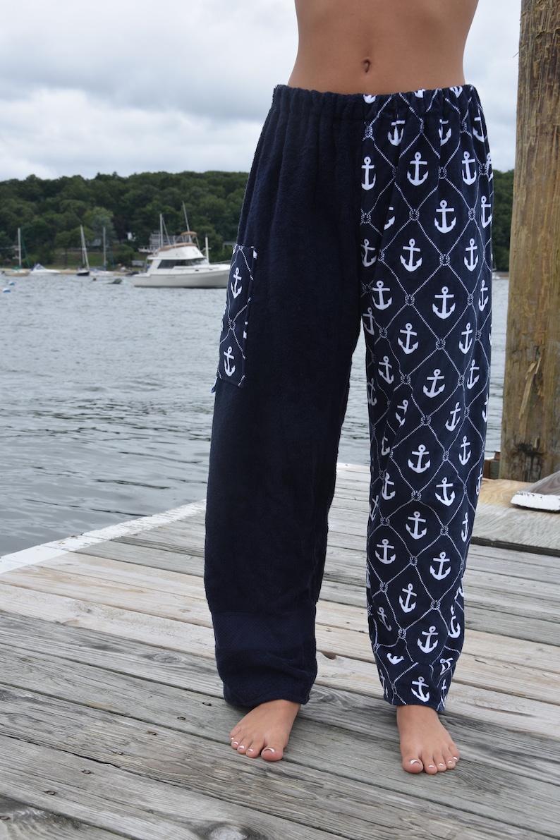 May include: Navy blue lounge pants with a white anchor and rope pattern. The pants have a large pocket on the left leg.
