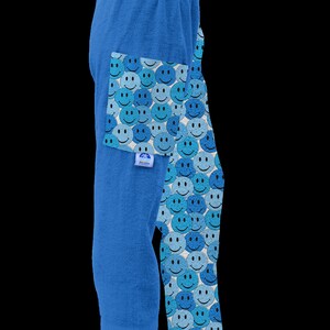 May include: Blue terry cloth lounge pants with a pattern of blue and light blue smiley faces. The pants have a drawstring waist and a pocket on the left side.