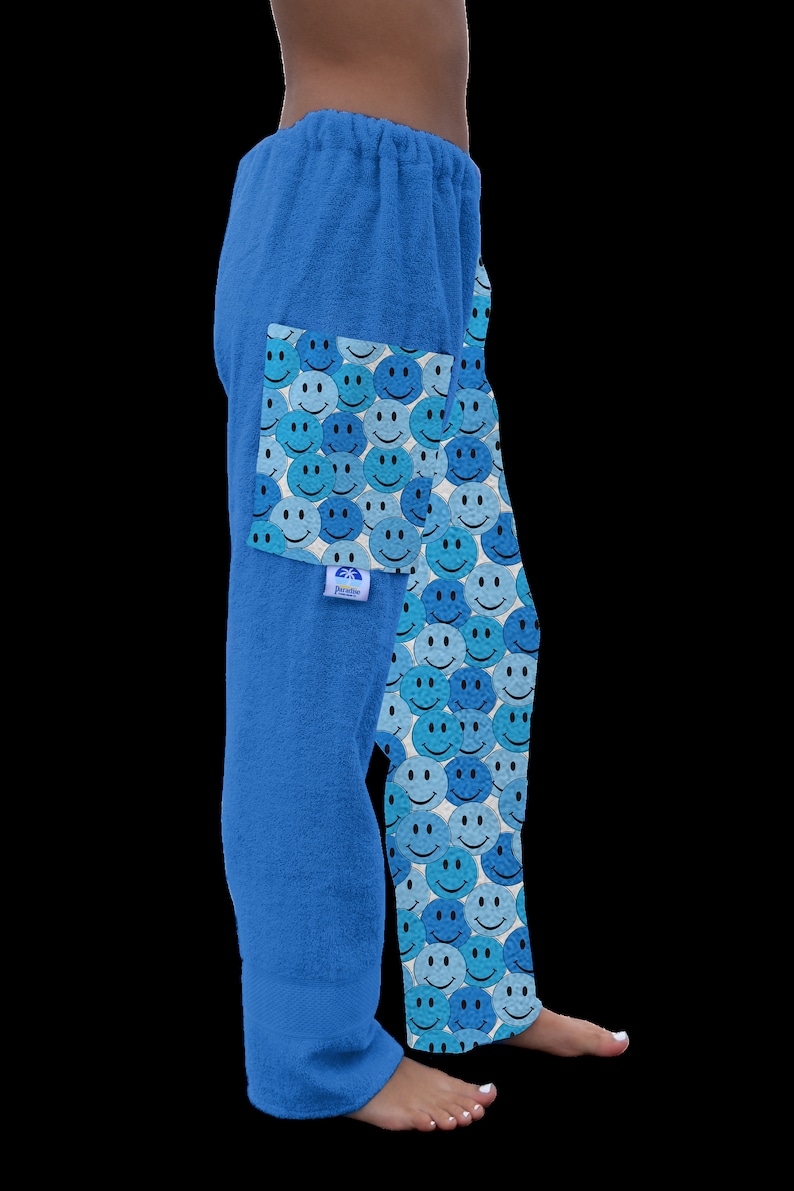 May include: Blue terry cloth lounge pants with a pattern of blue and light blue smiley faces. The pants have a drawstring waist and a pocket on the left side.