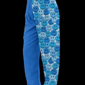 May include: Blue fleece pajama pants with a pattern of blue and white smiley faces on one leg.