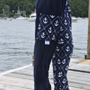May include: Navy blue terry cloth pants with a white anchor and rope pattern. The pants have a large pocket on the left leg with a white anchor and rope pattern.