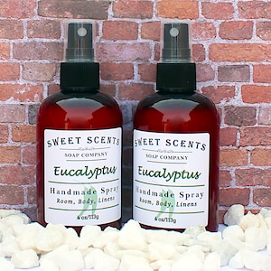 Pu&ograve; includere: Due flaconi da 113 g di spray per ambiente, corpo e biancheria profumato all'eucalipto. I flaconi sono trasparenti con liquido marrone e spruzzini neri. Le etichette sono bianche con testo nero che recita "Sweet Scents Soap Company" e "Eucalyptus Handmade Spray Room, Body, Linens".