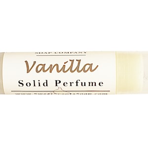 May include: A white tube with a label that reads "SOAP COMPANY Vanilla Solid Perfume www.SweetScentsSoap.com".