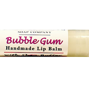 May include: A white tube of lip balm with a pink label that reads "Bubble Gum Handmade Lip Balm with Shea Butter".