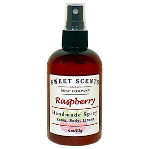 May include: A brown glass bottle with a black spray nozzle and a white label that reads "SWEET SCENTS SOAP COMPANY Raspberry Handmade Spray Room, Body, Linens 4 oz/113g".