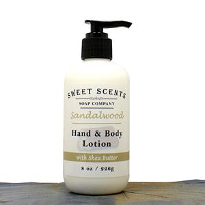May include: A white bottle of Sweet Scents Sandalwood Hand & Body Lotion with a black pump. The label includes the text "with Shea Butter" and indicates a volume of 8 oz / 226g.