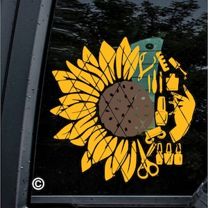 May include: A yellow and brown sunflower design with nail care tools. The design includes scissors, nail polish bottles, and a hand holding a nail polish brush. The background is a dark, blurred image of trees.