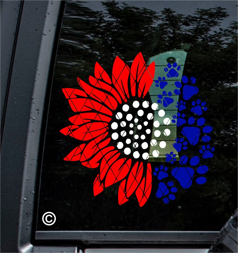 Puede incluir: Girasol rojo, blanco y azul con huellas de patas. El girasol es mitad rojo y mitad blanco con un centro blanco. Las huellas de patas son azules y llenan la otra mitad del girasol.
