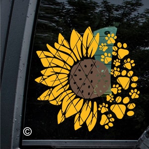 Puede incluir: Un girasol amarillo con un centro marr&oacute;n est&aacute; rodeado por un c&iacute;rculo de huellas de patas amarillas.