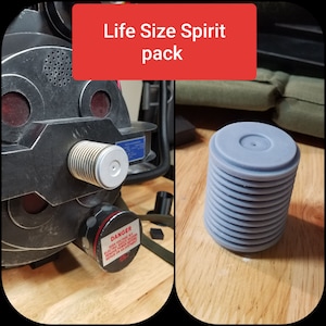 May include: A life-size Spirit pack prop, featuring a detailed, metallic-looking device with a cylindrical component and a stack of gray, circular pieces. The text "Life Size Spirit pack" is displayed on a red background.