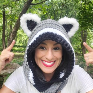 Puede incluir: Una capucha de ganchillo con tem&aacute;tica de mapache gris, negro y blanco con orejas de piel sint&eacute;tica. La capucha est&aacute; dise&ntilde;ada para usarse alrededor del cuello y la cabeza. Un accesorio divertido y caprichoso.