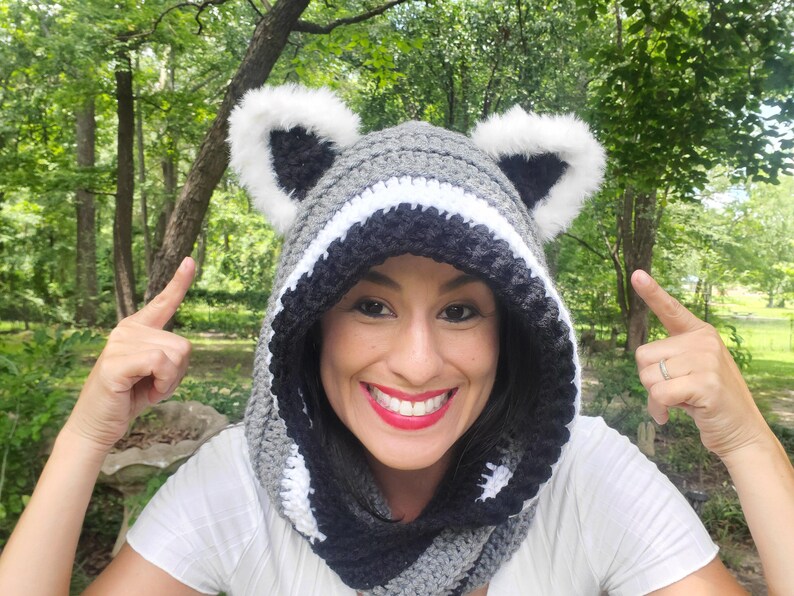 Puede incluir: Una capucha de ganchillo con tem&aacute;tica de mapache gris, negro y blanco con orejas de piel sint&eacute;tica. La capucha est&aacute; dise&ntilde;ada para usarse alrededor del cuello y la cabeza. Un accesorio divertido y caprichoso.
