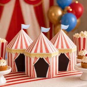 May include: Three hexagonal paper boxes designed to resemble circus tents with red and white vertical stripes, a scalloped yellow trim, and a small light blue flag on top. Each box features a dark opening with draped curtains on the front.