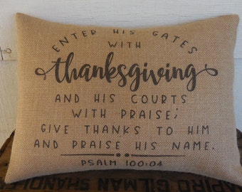 May include: A burlap pillow with the text "Enter his gates with thanksgiving and his courts with praise; give thanks to him and praise his name. Psalm 100:04" printed in black.
