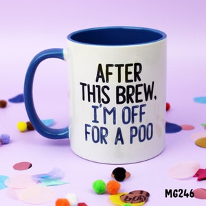 May include: White ceramic mug with a blue rim and handle. The mug has black text that reads "After this brew, I'm off for a poo." The mug is sitting on a purple surface with colourful confetti.