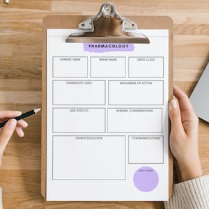 May include: A clipboard with a pharmacology template, featuring sections for generic name, brand name, drug class, therapeutic uses, and more. A hand holds a pencil, ready to write. A laptop and notebook are also visible.
