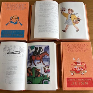 May include: Three orange hardback books with the title "Bibliotheca Mirovoi Literatury Dlya Detey" on the front cover. The first book has the text "Takhi Detyam" on the front cover. The second book has a black and white illustration of a girl in a yellow dress holding a basket. The third book has a black and white illustration of a car with animals inside.