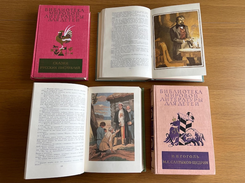 May include: A set of four vintage hardback books with pink and green covers. The books are titled "Bibliotheca Mirovoi Literatury Dlya Detey" and feature illustrations of a rooster, a man in a suit, a group of people in a village, and a pig. The books are in Russian.