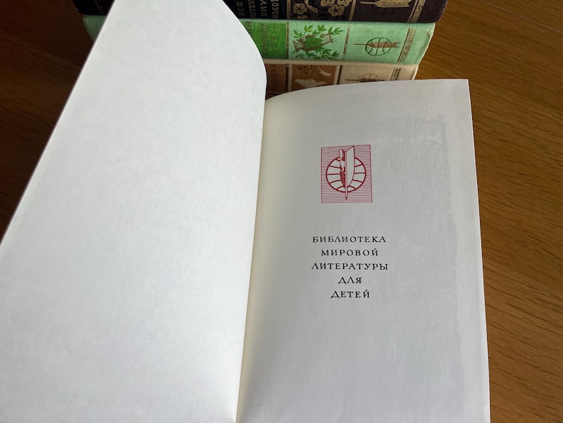 May include: A white book with a red logo and the text "Biblioteca мировой литературы для детей" on the cover.