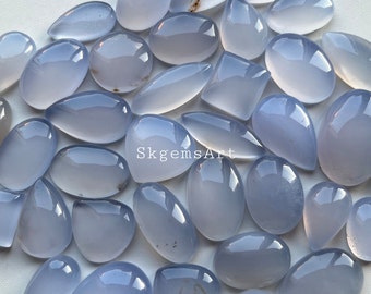 May include: A collection of 25 blue chalcedony cabochons, ranging in size and shape. The stones are translucent and have a light blue color. The cabochons are perfect for jewelry making or other craft projects.