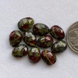 Pode incluir: Dez contas de pedra preciosa facetadas, de forma oval, de cor verde e vermelha. As contas são aproximadamente do tamanho de uma moeda de 25 centavos de dólar americano.