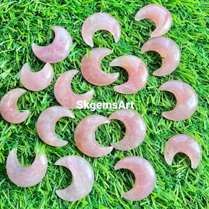 Cabujón de cuarzo rosa natural en forma de media luna, utilizado para la fabricación de joyas.