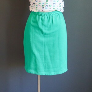 May include: A bright teal green skirt with a wide elastic waistband.