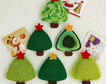 May include: Six crocheted Christmas tree ornaments in various shades of green. The ornaments are decorated with small stars in red, yellow, and orange.
