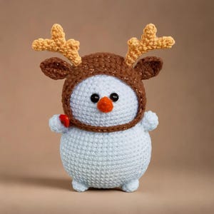 a crochet snowman with antlers and a carrot nose