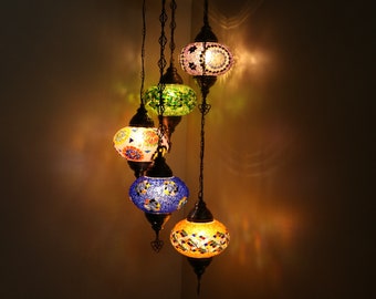 May include: A multi-tiered chandelier with five colorful glass globes. The globes are decorated with mosaic patterns and emit a warm glow.