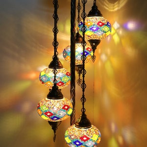 May include: A floor lamp with a black metal base and five colorful mosaic glass globes. The globes are suspended from chains and have a variety of geometric patterns.