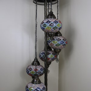 May include: A floor lamp with a twisted metal stand and four colorful mosaic glass globes. The globes are suspended from chains and have intricate geometric patterns.