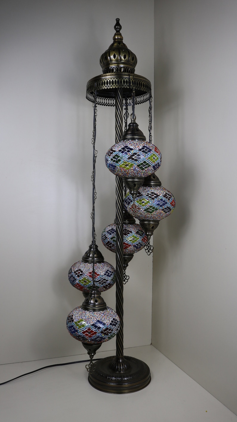 May include: A floor lamp with a twisted metal stand and four colorful mosaic glass globes. The globes are suspended from chains and have intricate geometric patterns.