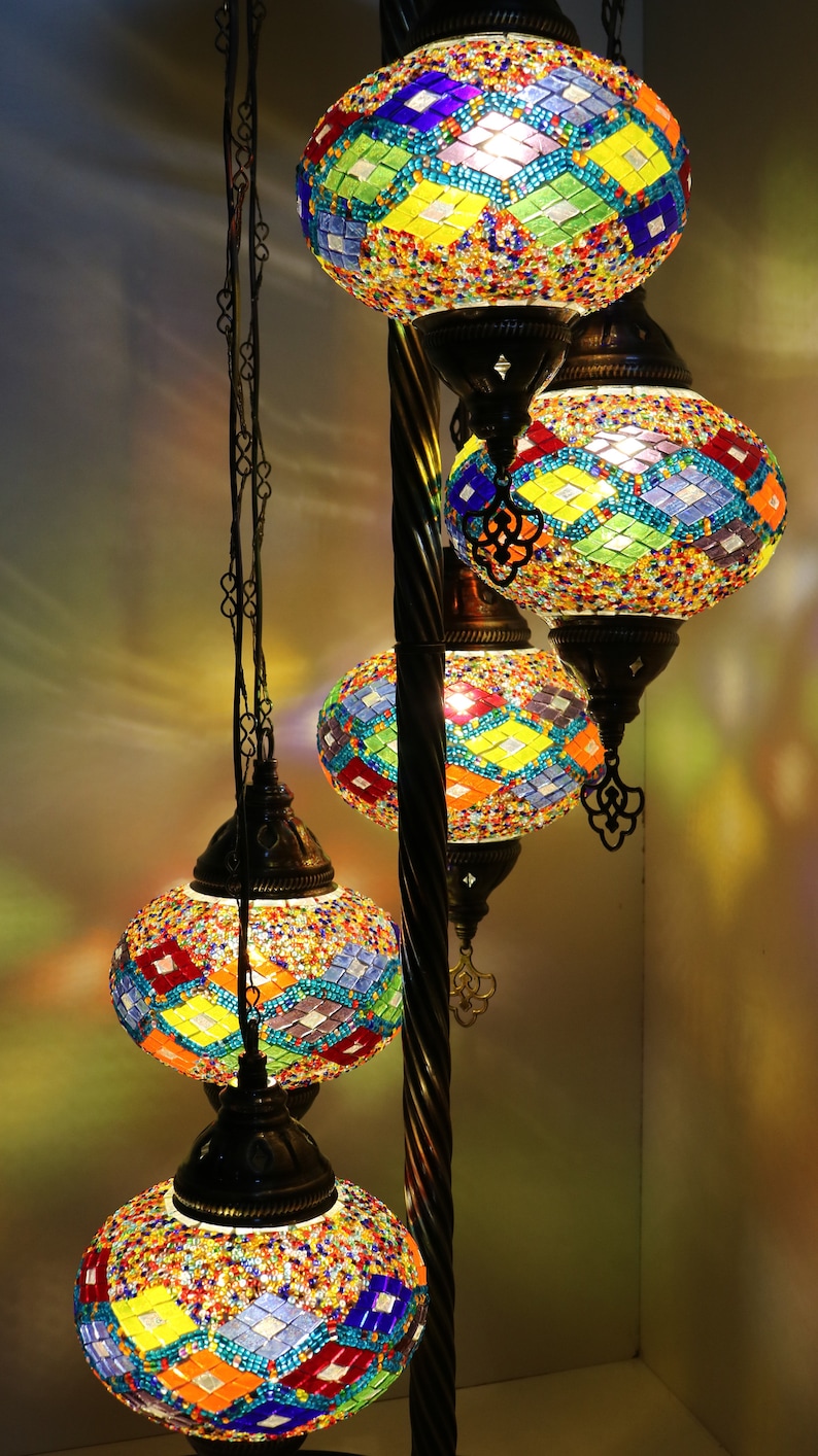 May include: A floor lamp with five colorful mosaic glass globes. The globes are in shades of blue, green, yellow, red, and orange. The lamp has a black metal base and a twisted metal pole.