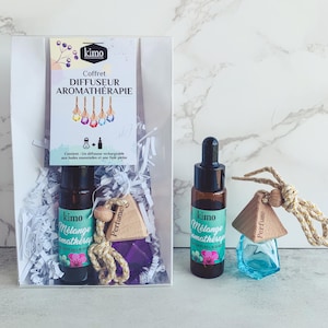 Peut inclure: Coffret d'aromathérapie avec une boîte transparente contenant une bouteille d'huile essentielle, une petite bouteille en verre bleue et une étiquette de parfum en bois. Le coffret comprend une carte.